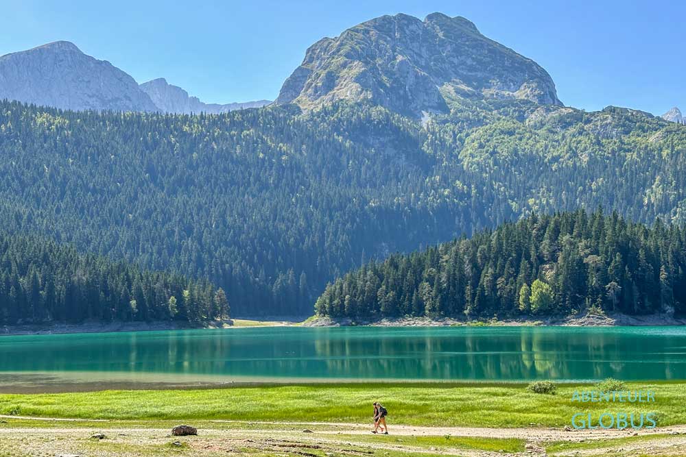 Wanderer am Schwarzen See mit Blick auf das Durmitormassiv und den Berg Bobotov Kuk in Montenegro