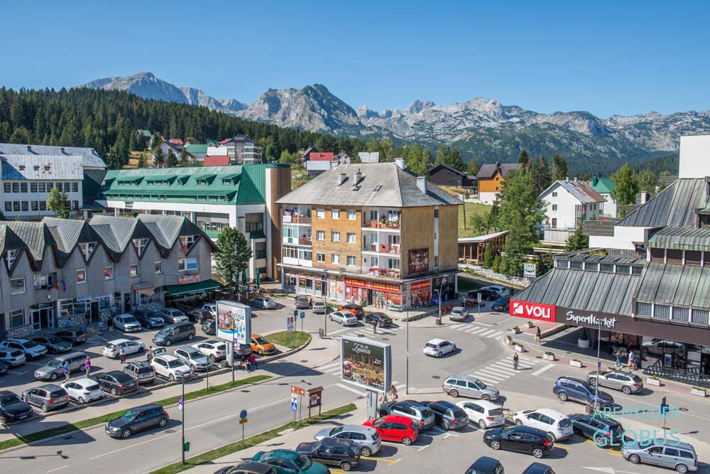 Hauptkreuzung mit Häusern, Supermarkt und Parkplätzen in Zabljak im Nationalpark Durmitor