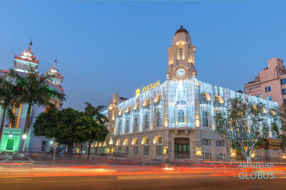 AYA Bank (Ayeyarwady Bank) in Yangon. Die Bank wird am Abend mit Lichterketten illuminiert.