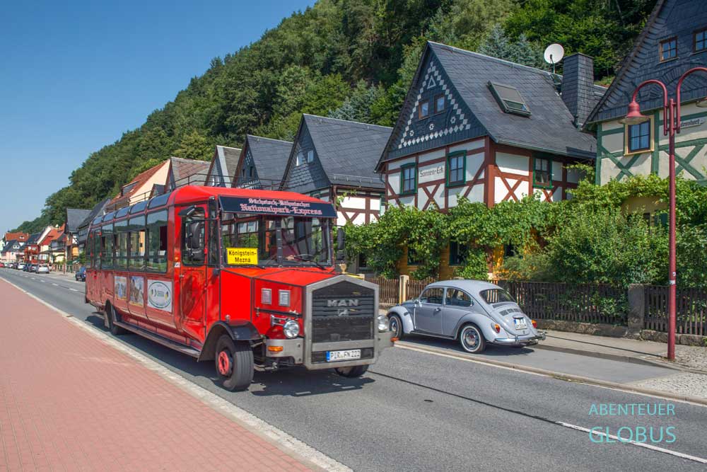 Roter Oldtimer-Bus (Sächsisch-Böhmische Nationalpark-Express) und grauer VW Käfer in Postelwitz, einen Ortsteil von Bad Schandau