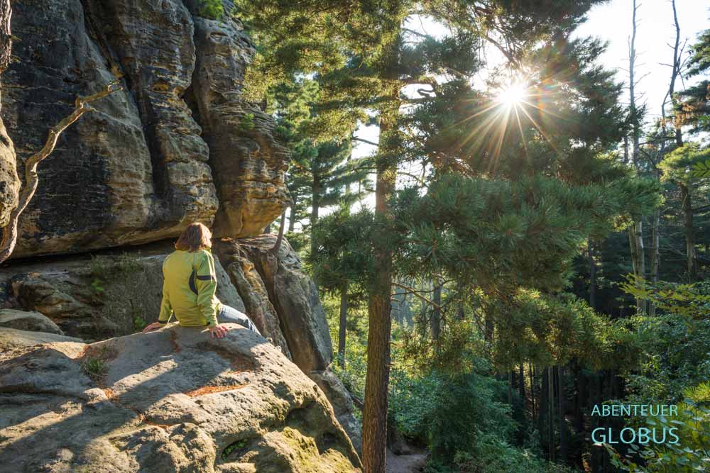 Wanderin beim Sonnenaufgang auf dem Kleinen Bärenstein in der Sächsischen Schweiz.