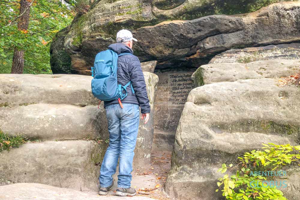 Wanderer vor der Thümmelgrotte mit Inschrift nahe der Brandaussicht bei Hohnstein, Sachsen
