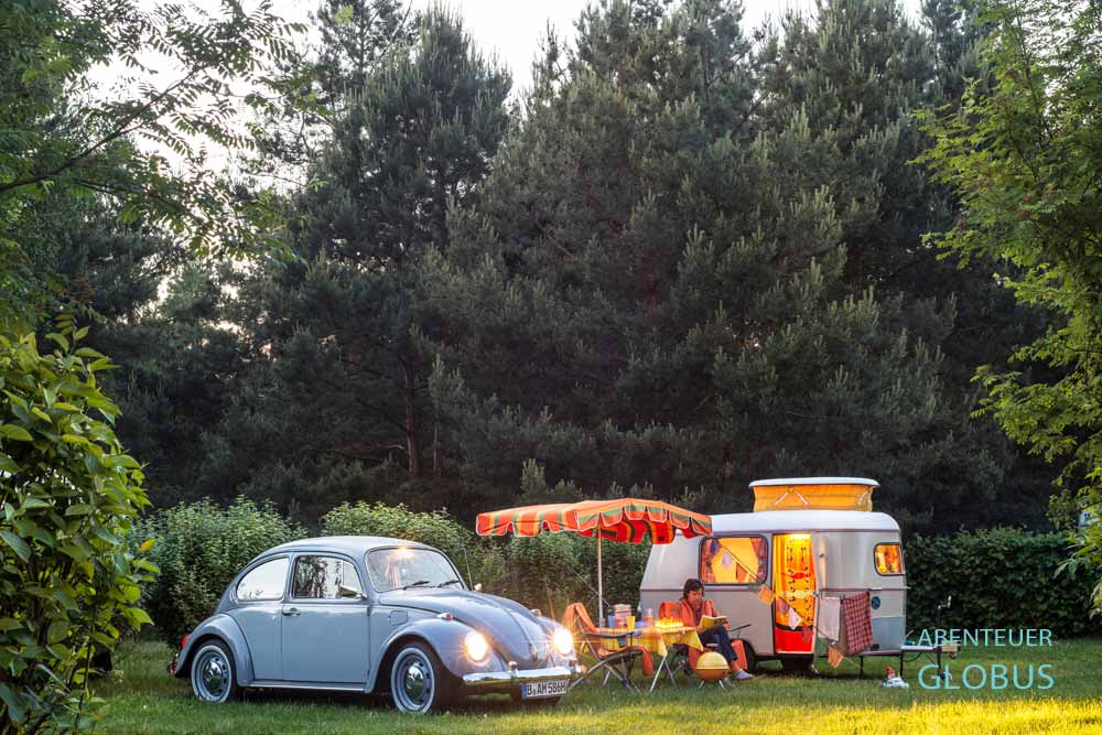 Gespann mit grauem VW Käfer und Wohnwagen Puck auf einem Campingplatz bei Meißen in Sachsen