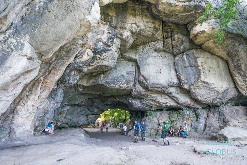 Wanderer im Felsentor Kuhstall am Malerweg, oberhalb des Kirnitzschtals bei Bad Schandau, Sachsen