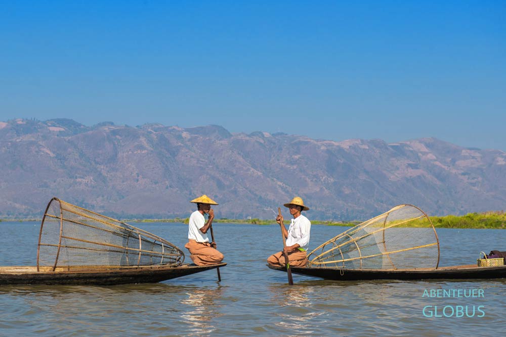 Zwei Intha-Fischer mit traditionellen Fischreusen sitzen auf Booten auf dem Inle-See bei Nyaungshwe.