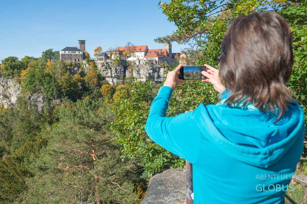 Urlauberin fotografiert die Burg Hohnstein von der Aussicht Ritterfelsen in Hohnstein.