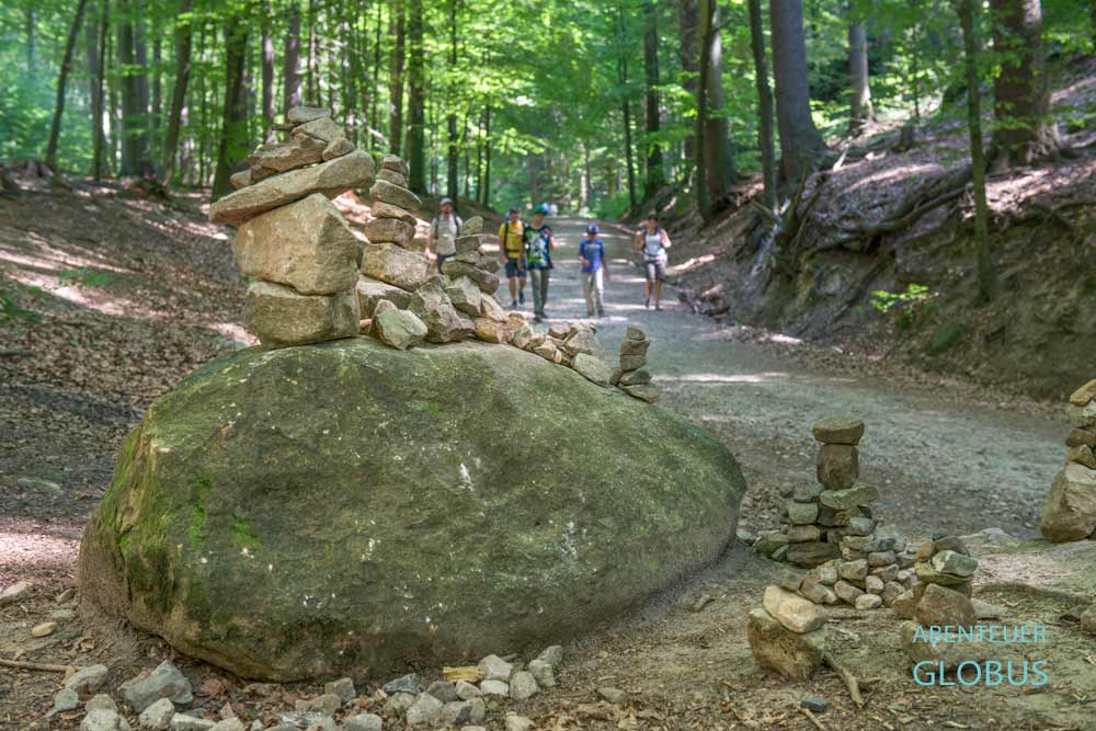 Familie mit Kindern auf der Wanderung zum Kuhstall, und Steinmännchen am Malerweg im Vordergrund, Nationalpark Sächsische Schweiz