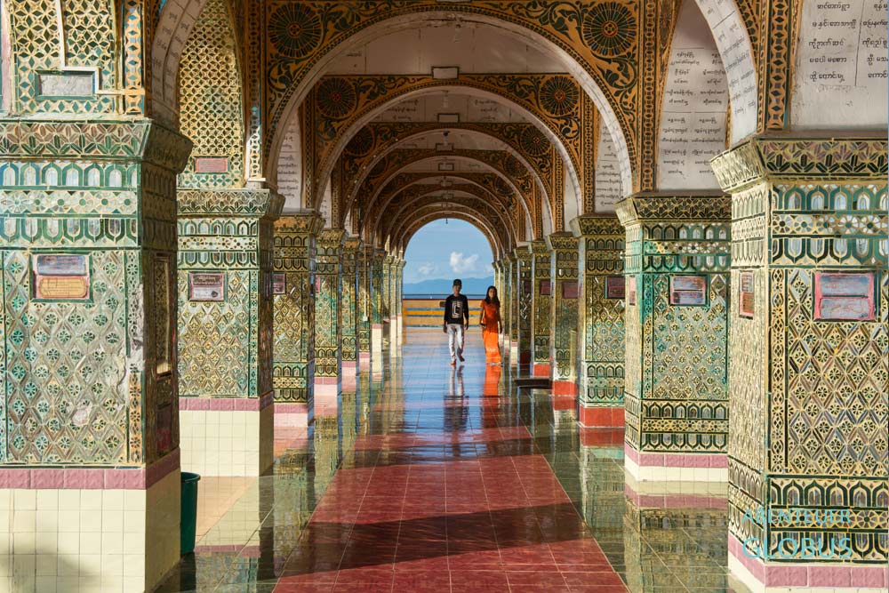 Zwei Personen stehen auf dem Mandalay Hill zwischen Rundbögen mit Spiegelfliesen in Mandalay