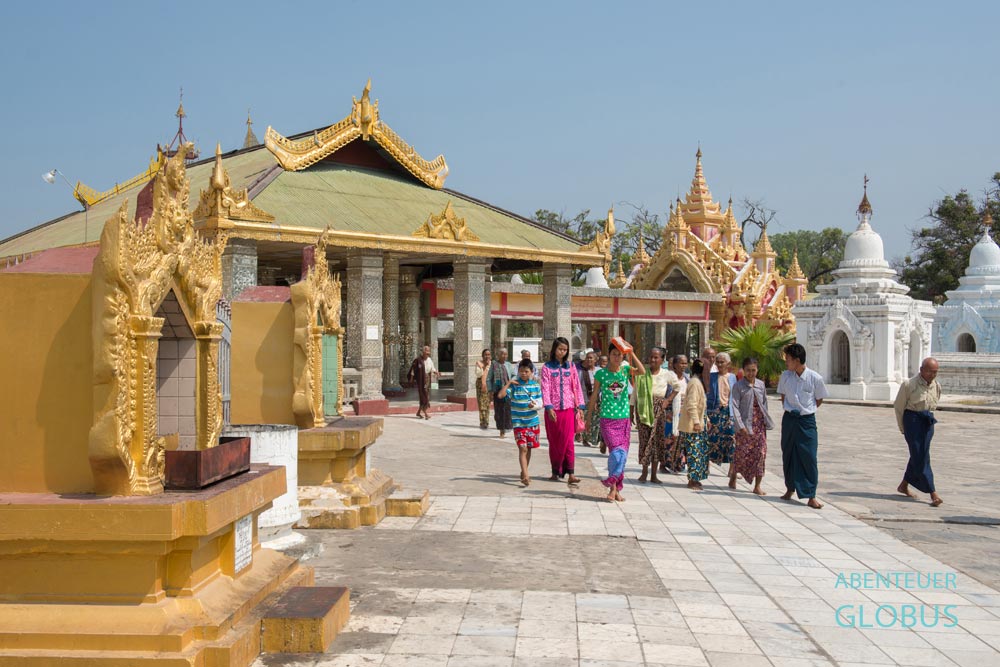 Pilger und Besucher auf den Marmorfliesen der Kuthodaw-Pagode auf dem Weg zum Hauptheiligtum