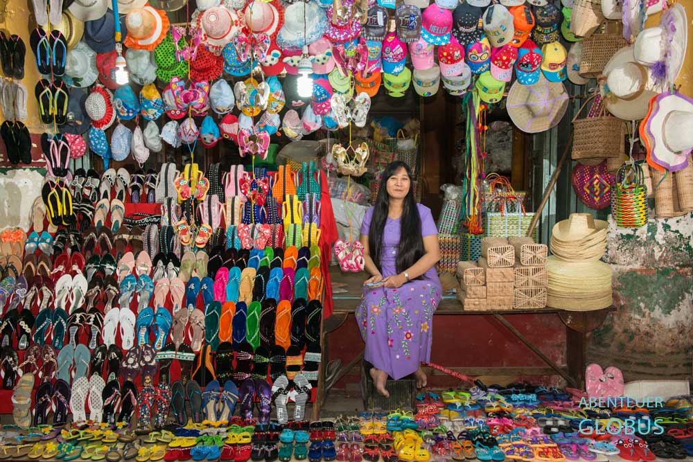 Im Zeigyo-Markt in Mandalay verkauft eine Frau Schuhe, Mützen und Hüte aus ihrem Verkaufsstand.