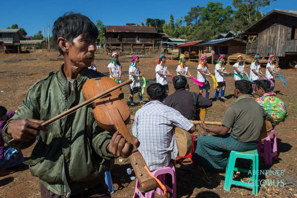 Padaung-Frauen tanzen in traditioneller Kleidung zu Musik auf dem Festplatz in Panpet, Myanmar.