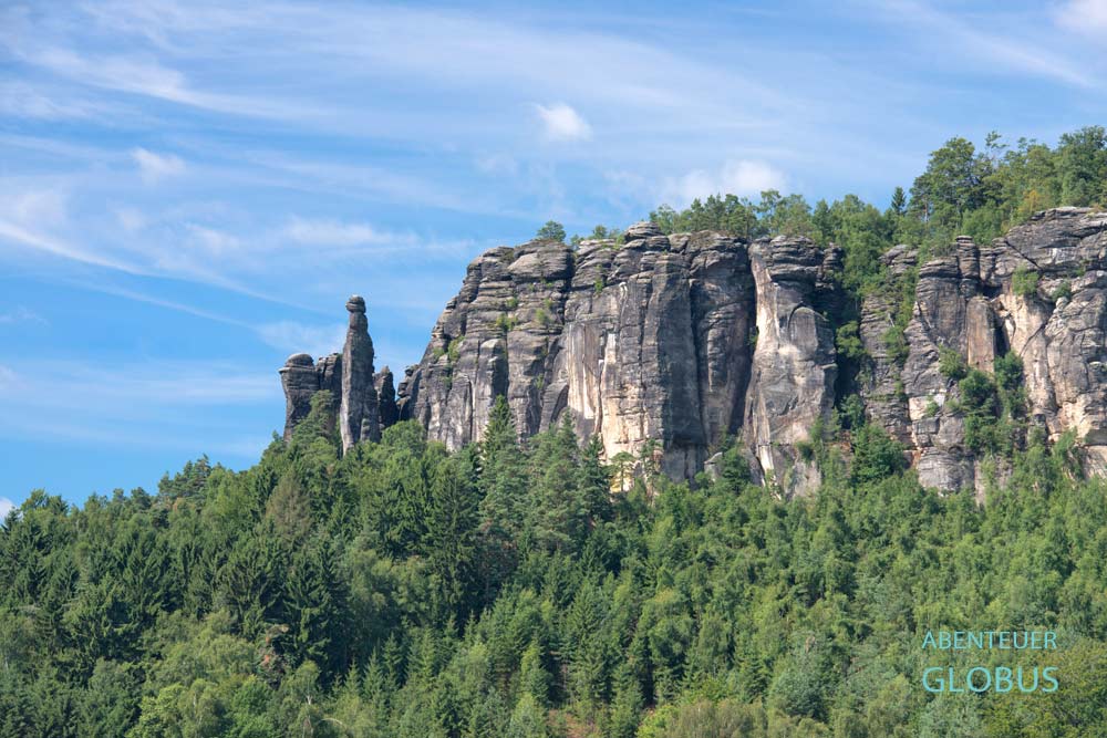 Im Wald zerklüfteter Tafelberg Pfaffenstein mit Felsnadel Barbarine (links)