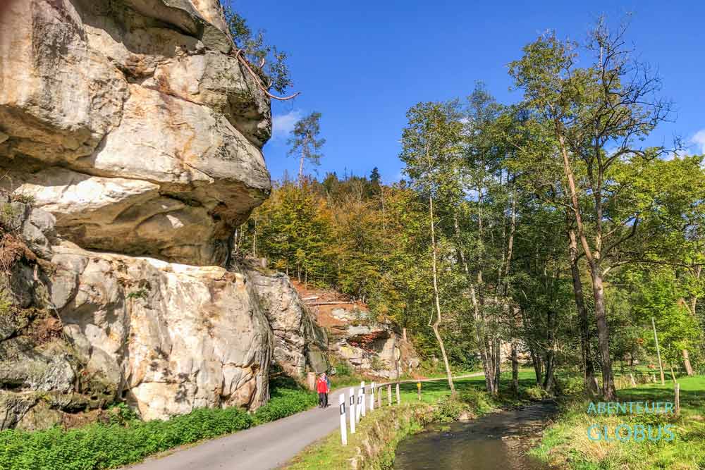 Wanderer auf Weg mit Felsen im Polenztal am Fluss Polenz