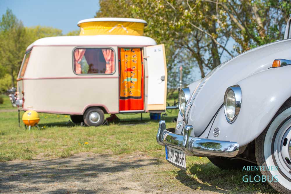 Im Vordergrund grauer VW Käfer, dahinter Wohnwagen Eriba Puck auf dem Campingplatz Nikolsdorfer Berg im Elbsandsteingebirge