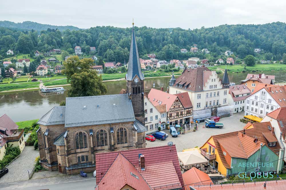 Blick von der Burgruine Wehlen auf die Radfahrerkirche am Marktplatz von Stadt Wehlen, dahinter die Elbe und der Ortsteil Pötzscha