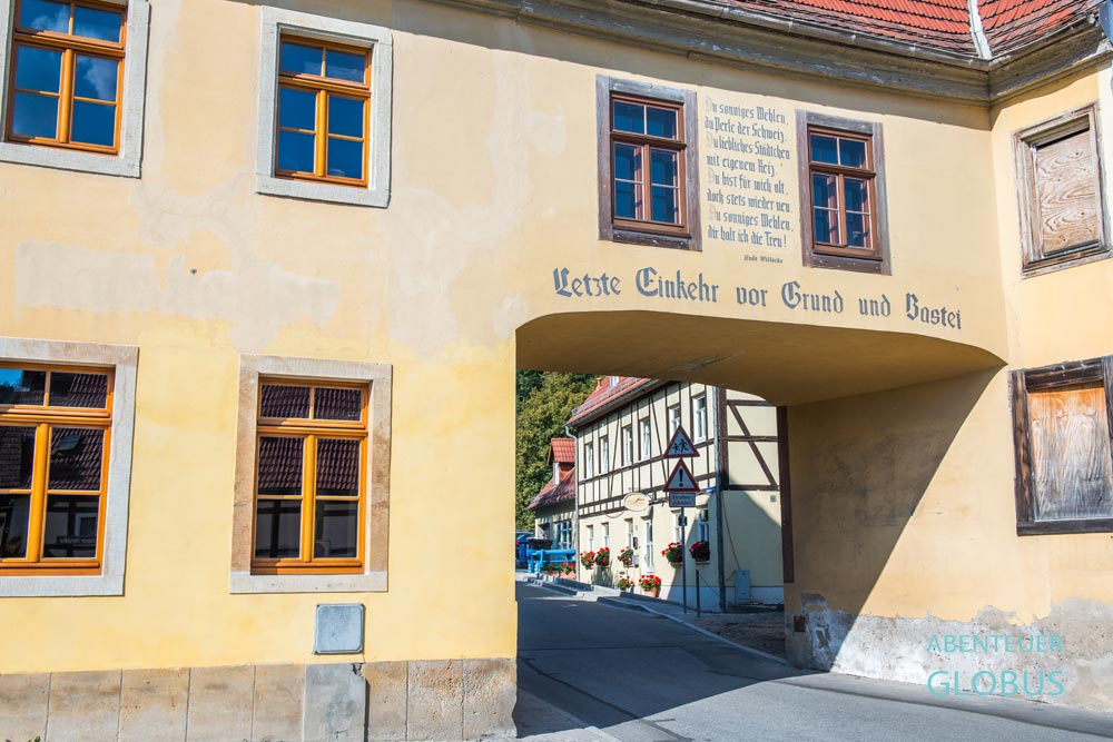 Gelbes Torhaus mit Spruch an der Fassade in Wehlen, Sächsische Schweiz