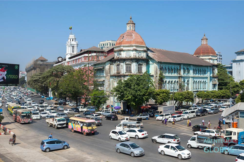 Das Kolonialgebäude Division Court mit viel Verkehr an der Strand Road in Yangon