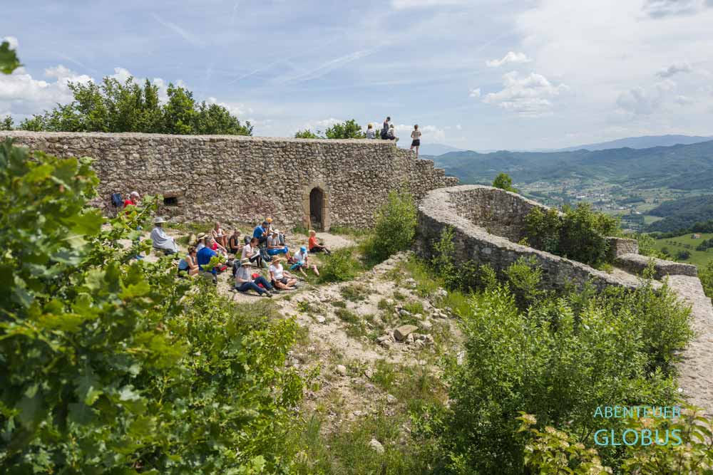 Eine Menschengruppe meditiert und schöpft Kraft auf der Sonnenpyramide in Visoko.