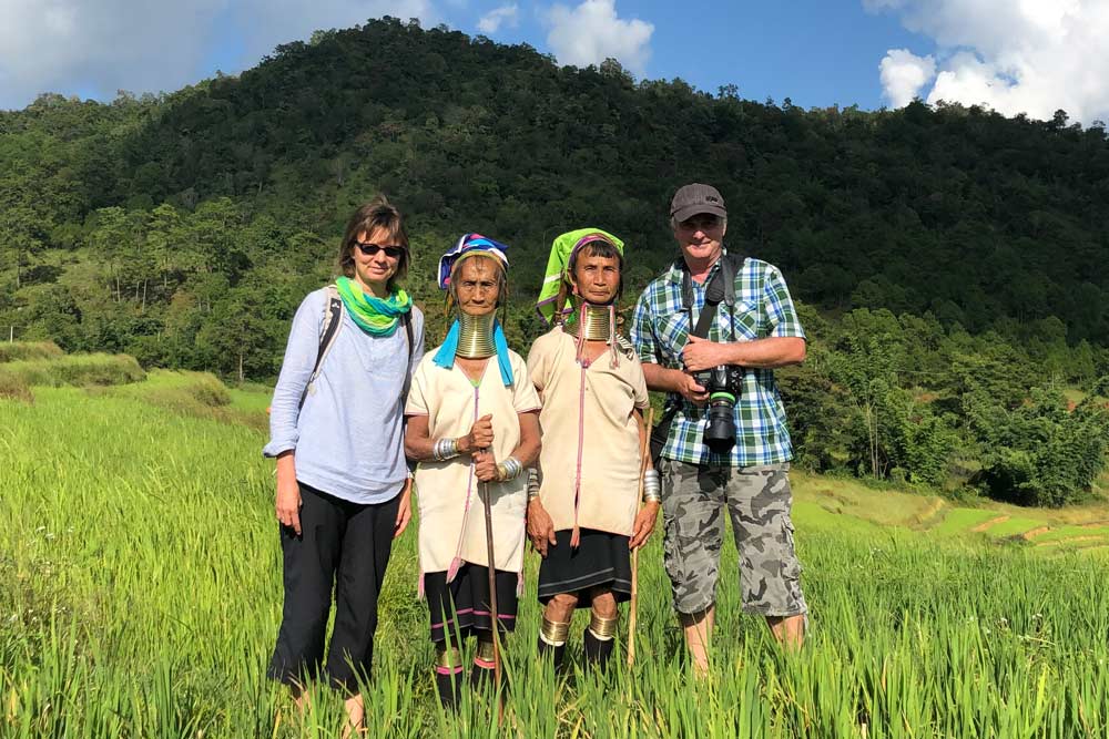 Annett und Mario vom Reiseblog Abenteuerglobus mit zwei Langhalsfrauen der Ethnie Padaung im Reisfeld in Myanmar