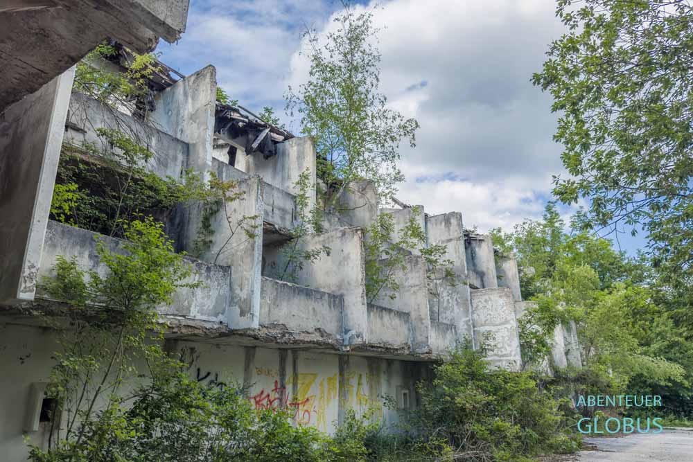 Vom Bäumen und Büschen bewachsene Hotelruine nahe dem Großen Pliva-See