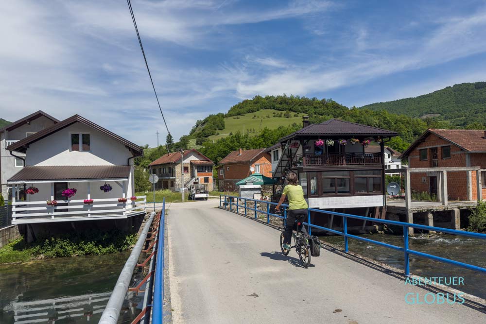 Radfahrerin auf einer Brücke im Dorf Jezero bei Jajce