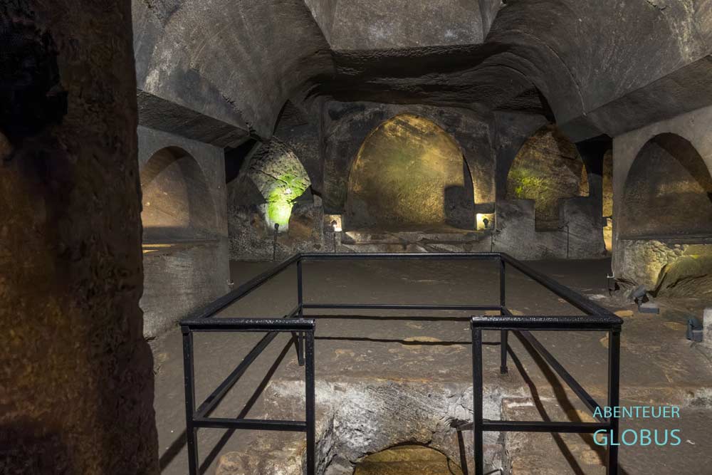 Erste Ebene mit beleuchteten Nischen und Zugang zur zweiten Ebene der unterirdischen Kirche in den Katakomben von Jajce