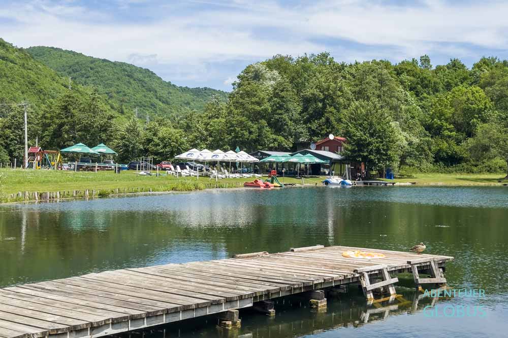 Badesteg und im Hintergrund die Tropico Bar am See Dol im Dorf Jezero nahe Jajce