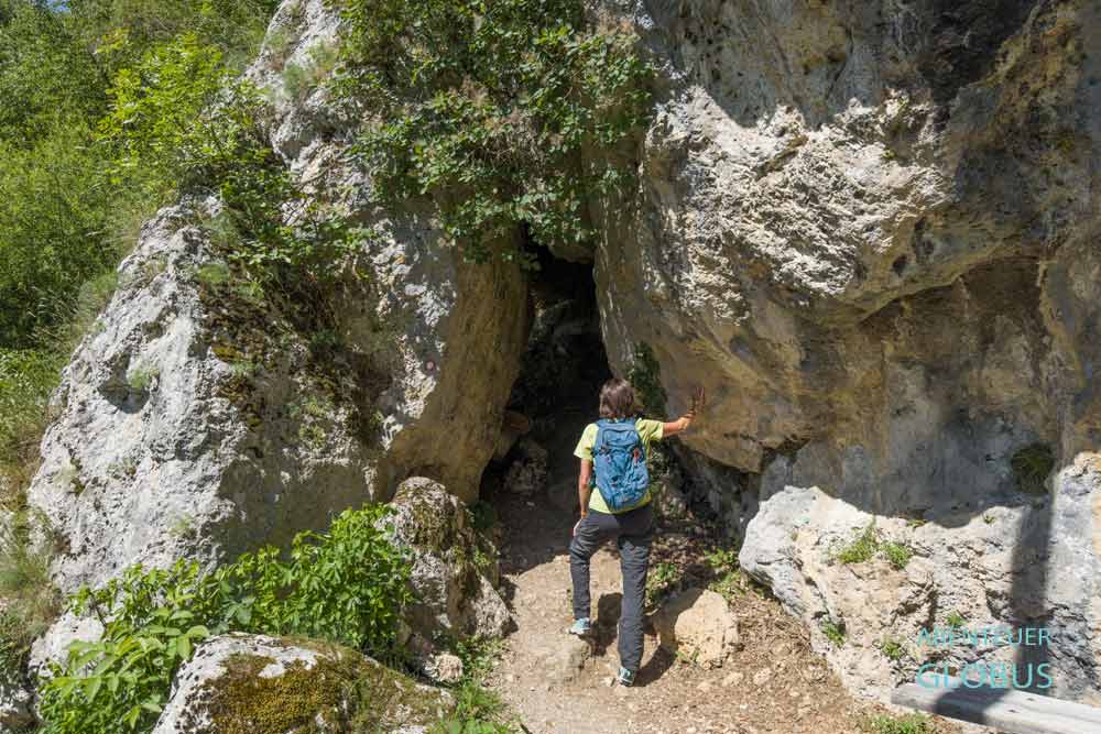 Wanderin vor einem kleinen Felsentor auf dem Weg zur Quelle der Krupa in Krupa na Vrbasu