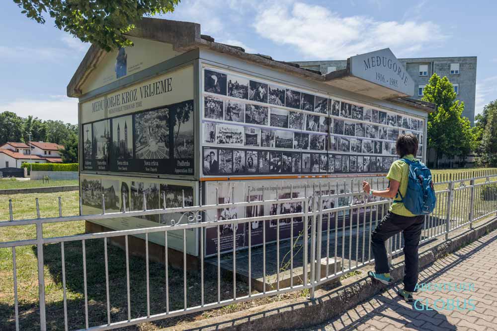 Touristin vor dem Haus mit Fotos von Medjugorje 1916-1985