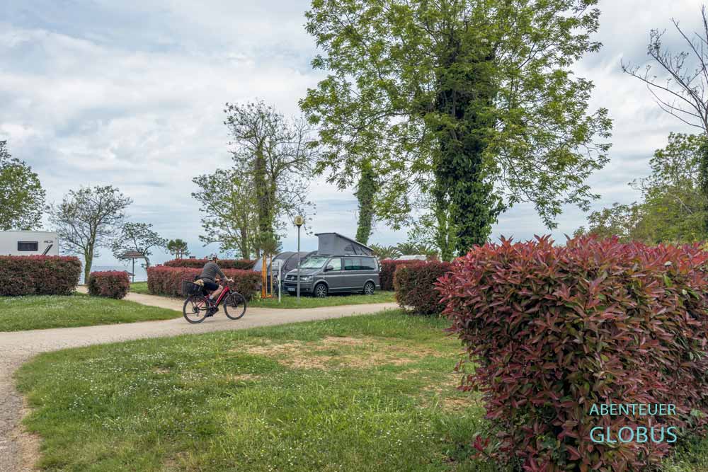 Radfahrer und Stellplätze mit Hecken des Campingplatzes Aminess Planet Camping Maravea bei Novigrad, Kroatien