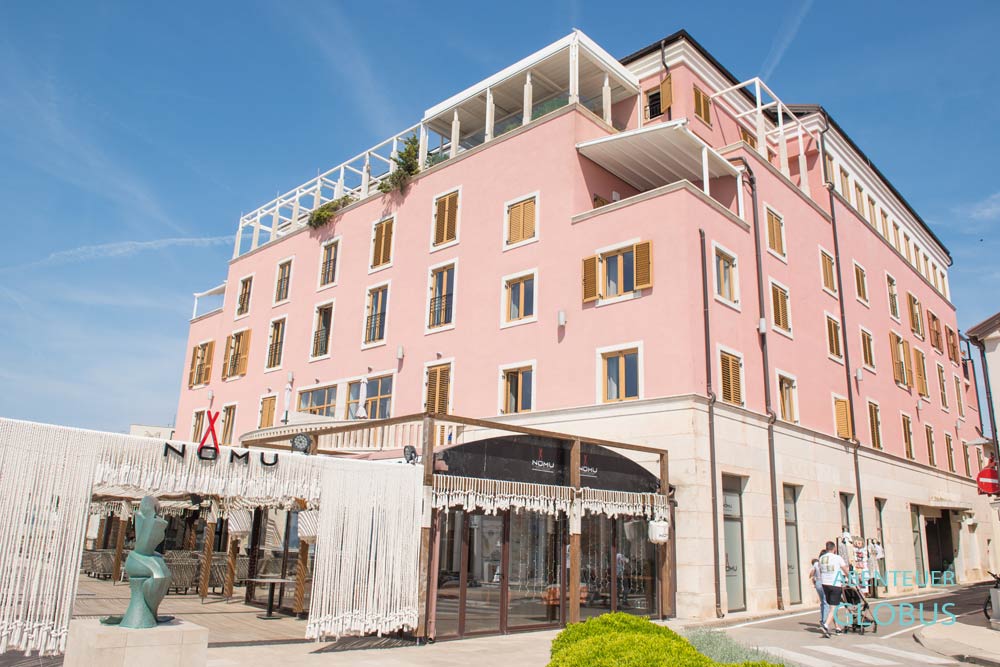 Rosafarbenes Hotel Rotonda Inn und japanisches Restaurant Nomu an der Promenade in Novigrad in Istrien in Kroatien