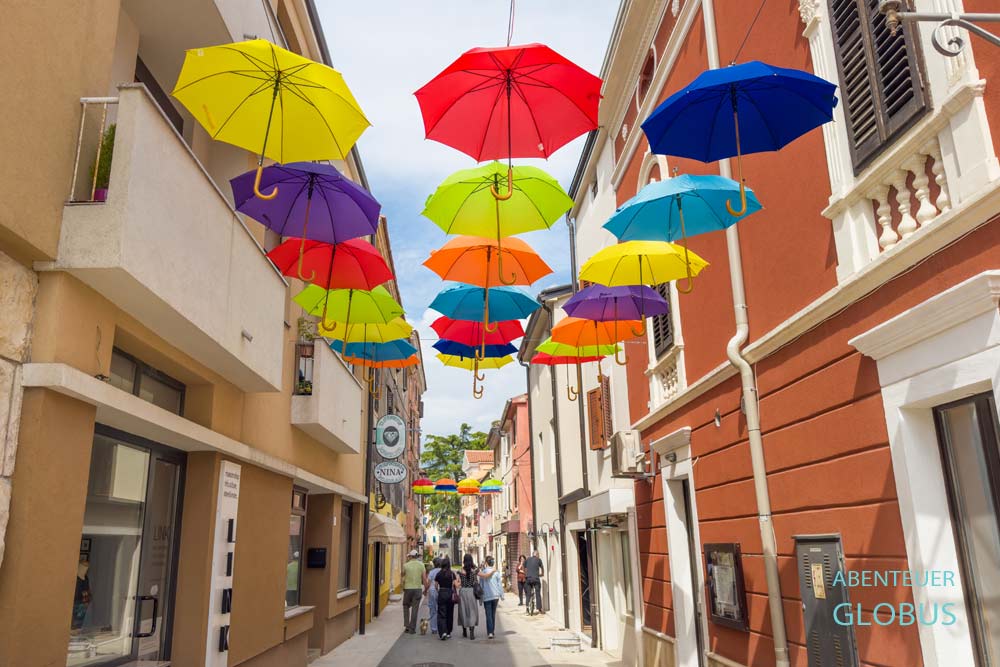 Bunte Regenschirme in einer Altstadtgasse von Novigrad