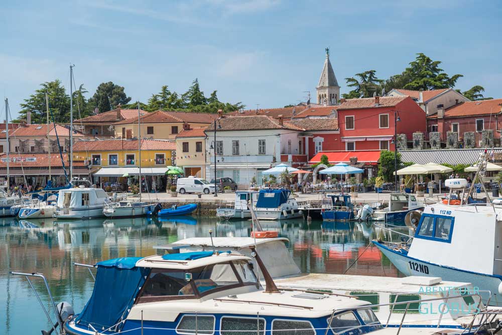 Stadthafen Mandrac in Novigrad, bunte Häuser an der Promenade und Glockenturm der Kirche St. Pelagius