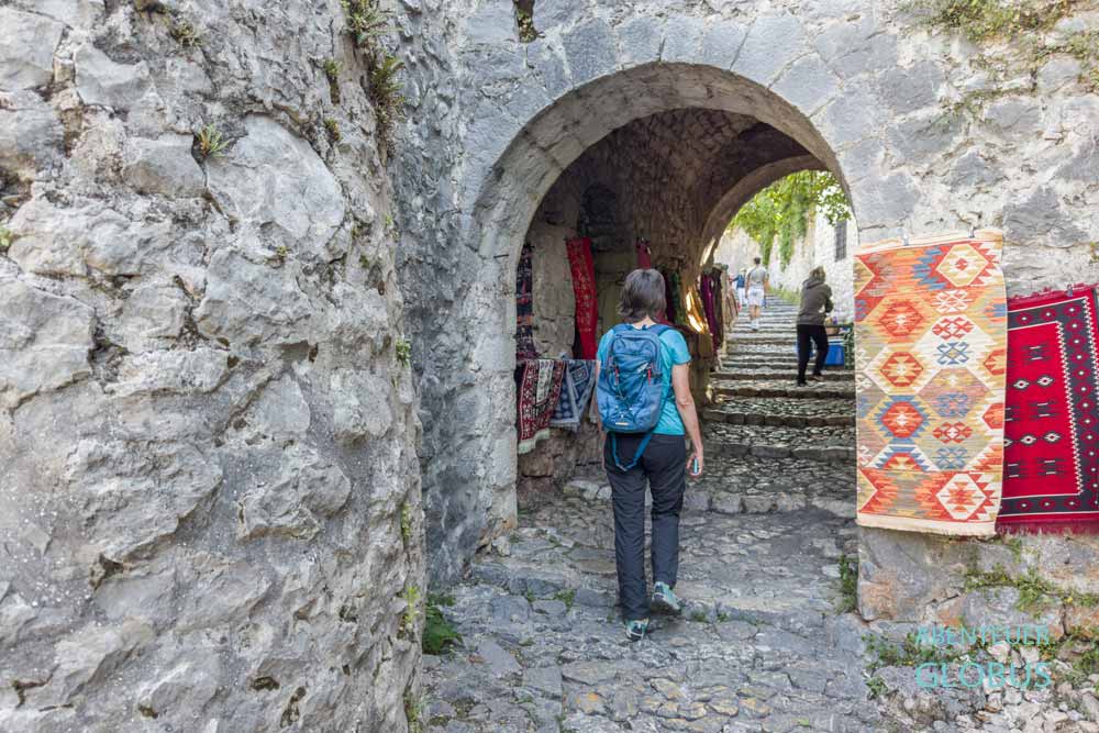 Touristin am Unteren Eingangstor in die Altstadt von Pocitelj in Bosnien und Herzegowina