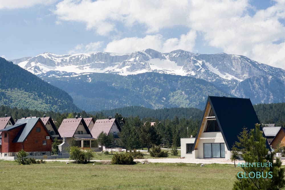 Ferienhäuser im Hauptort Risovac, dahinter schneebedecktes Cvrsnica-Gebirge im Naturpark Blidinje
