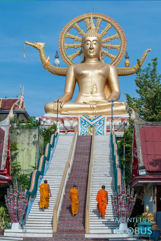 Drei buddhistische Mönche gehen die Treppen hinauf zum Big Buddha auf Koh Samui