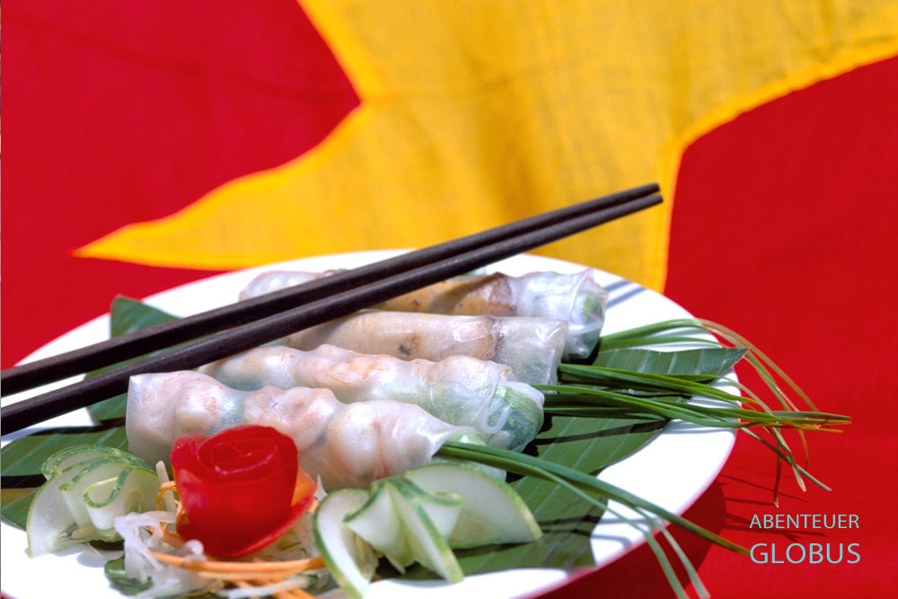 Frische Frühlingsrollen mit Shrimps und Gemüse als Beilage, serviert auf Bananenblättern in Vietnam.