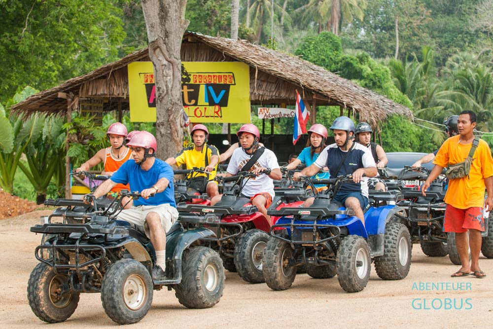 Teilnehmer einer Quad-Tour sitzen vor dem Start einer Inseltour auf Koh Samui in Thailand.