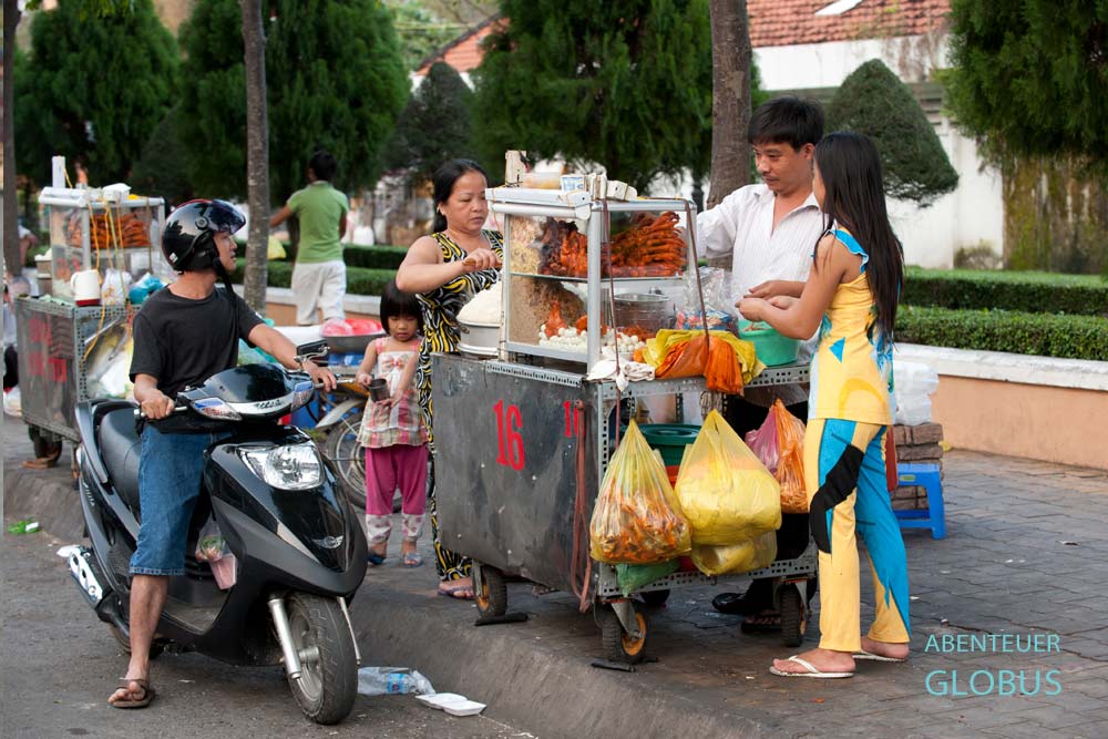 Mobiler Streetfood-Stand mit Gästen auf der Straße in Vietnam