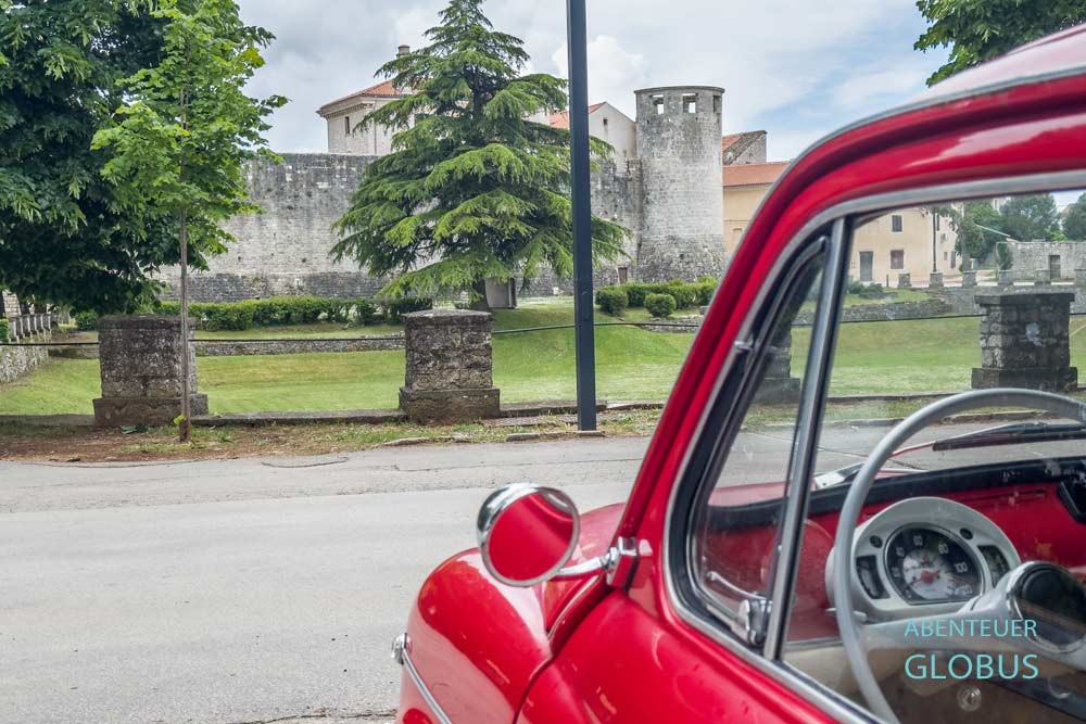 Roter Fiat Oldtimer und Kastell Morosini-Grimani im Hintergrund in Svetvincenat auf der Halbinsel Istrien in Kroatien