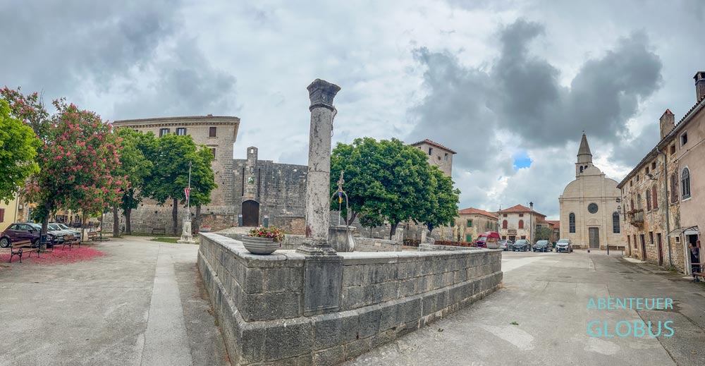 Hauptplatz mit Brunnen, Kastell Morosini-Grimani und Pfarrkirche Maria Verkündigung in Svetvincenat auf der Halbinsel Istrien in Kroatien
