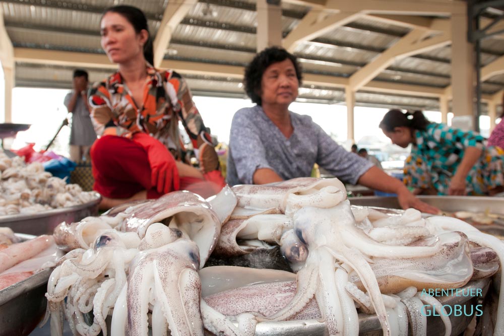 Zwei Verkäuferinnen an einem Marktstand mit frischen Tintenfischen in Can Tho, Vietnam.