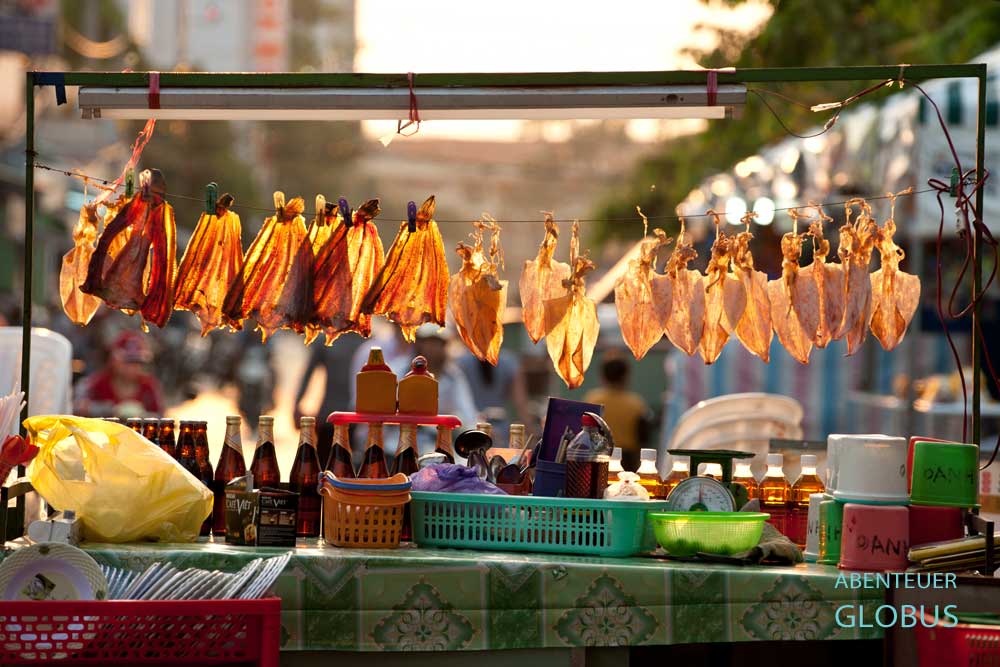 Getrocknete Tintenfische hängen an einer Leine an einem Streetfood-Stand in Vietnam.