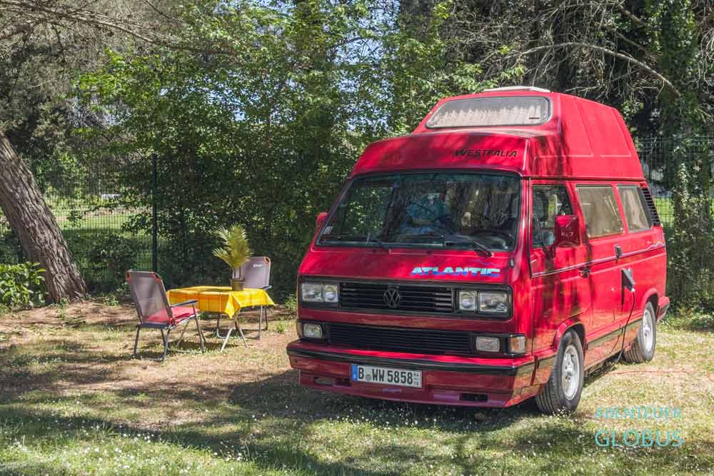 Roter Oldtimer Bulli VW T3 auf einem Stellplatz vom Campingplatz Camping Orsera in Vrsar