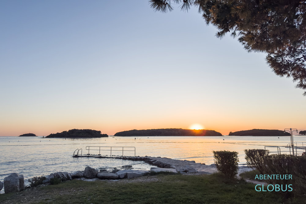 Sonnenuntergang hinter drei Inseln, gesehen vom Strand Orsera in Vrsar