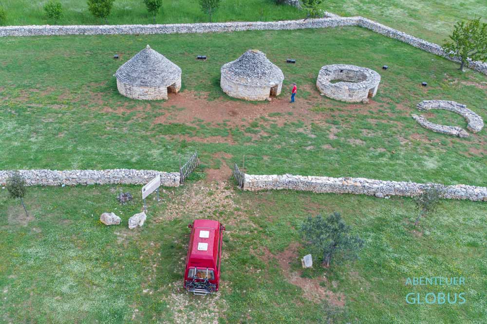 Roter VW T3 Bulli und traditionelle istrische Steinhütten (Tri Kazuna) bei Vodnjan in Istrien in Kroatien