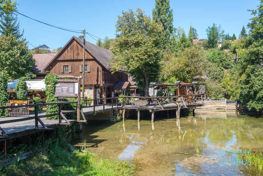 Brücke über den Fluss Slunjcica und Eingang mit Haus zum Museum Slovin Unique Rastoke in Slunj, Kroatien