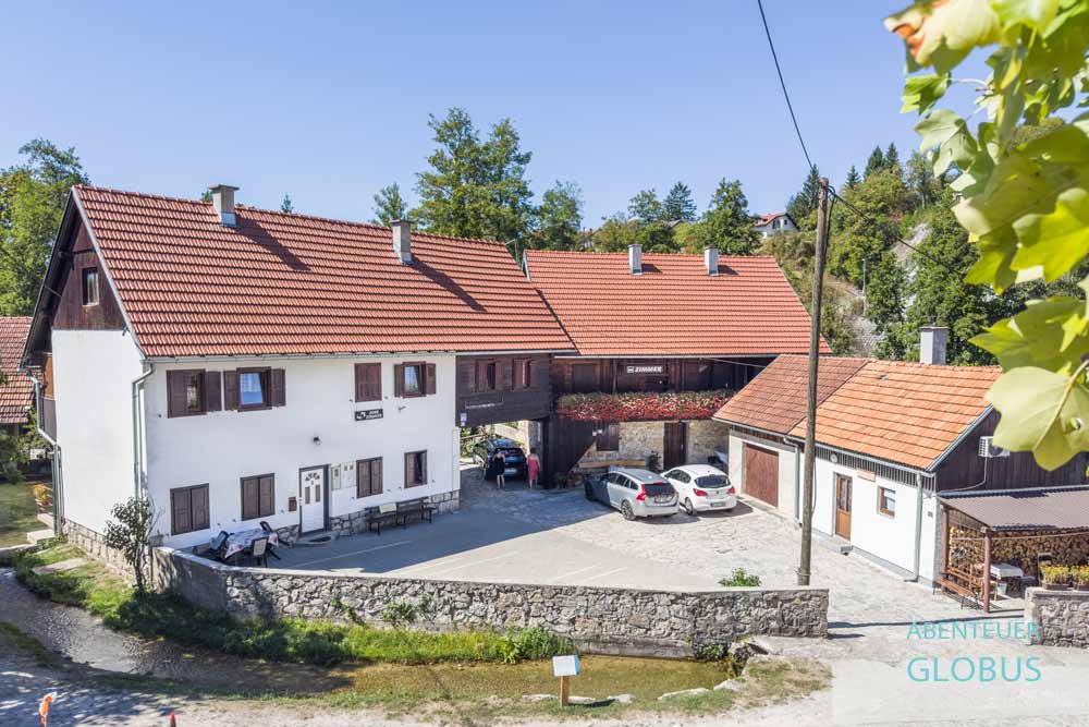 Häuser und Parkplatz des Guest House Vuceta im Wassermühlendorf Rastoke bei Slunj, Kroatien
