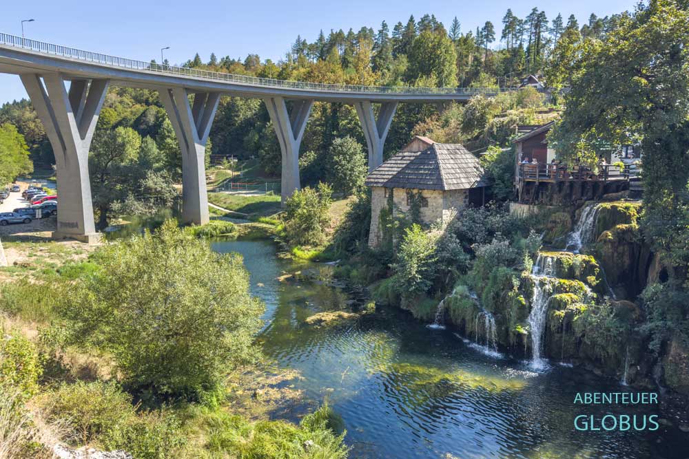 Wasserfälle und die Tonkovic-Brücke über dem Fluss Korana im Hintergrund in Slunj-Rastoke