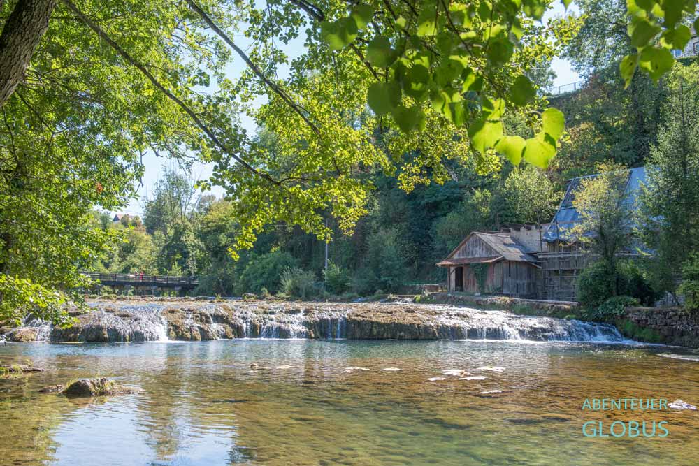 Fluss Slunjcica mit Kaskaden, alter Wassermühle und Brücke Mocanov in grüner Natur in Slunj